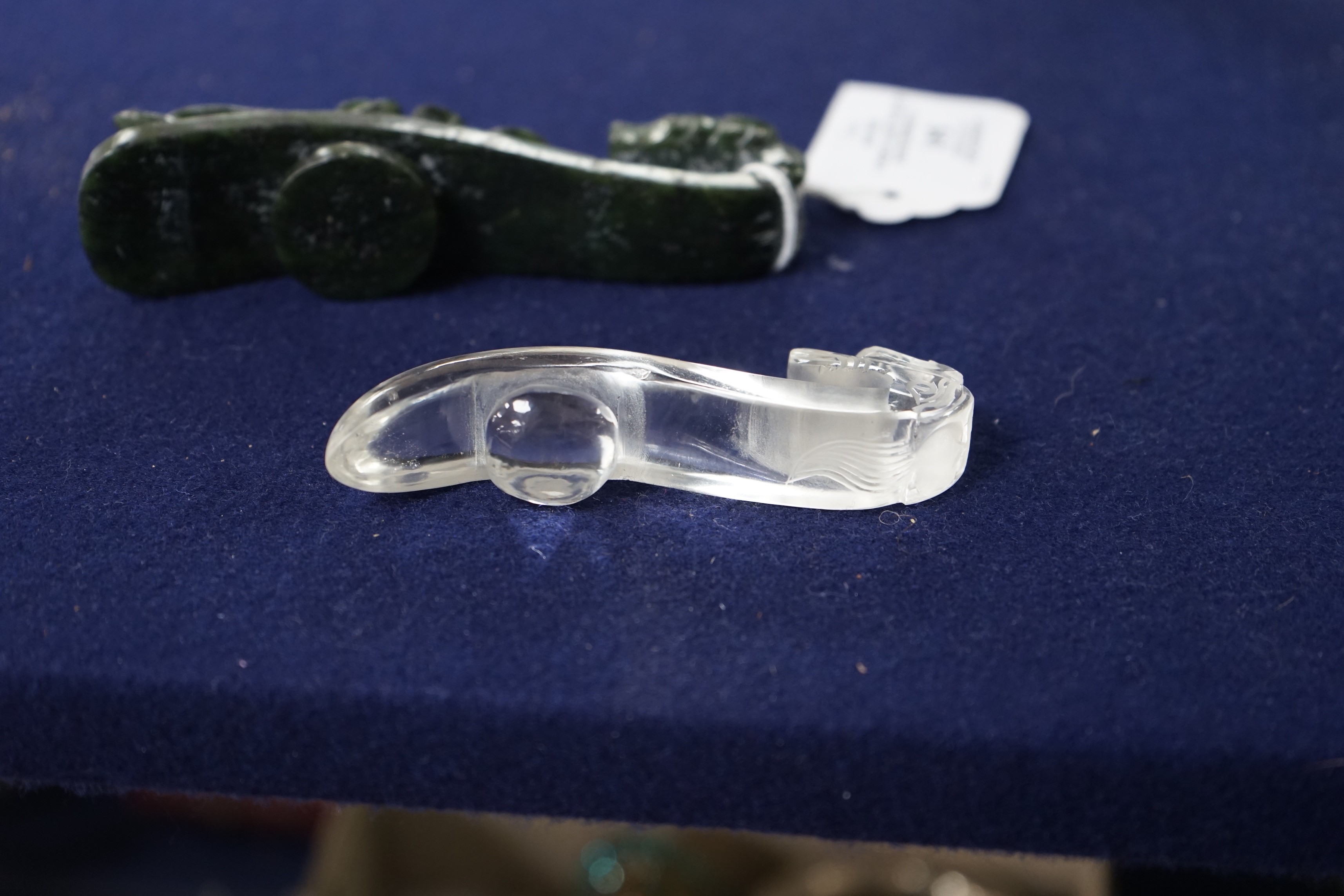 A Chinese rock crystal belt hook and a Chinese spinach green jade belt hook (2), largest 12cms long
